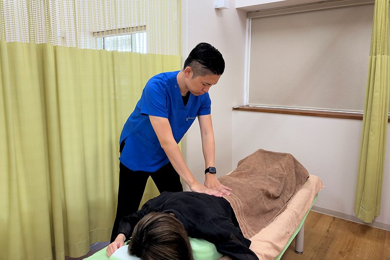 みやび鍼灸接骨院で背中から腰まわりへ手技を行う様子